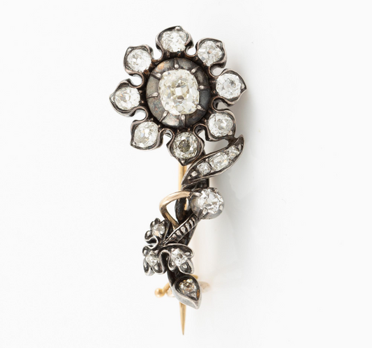 Vintage-style brooch with central gemstone accents on a white background